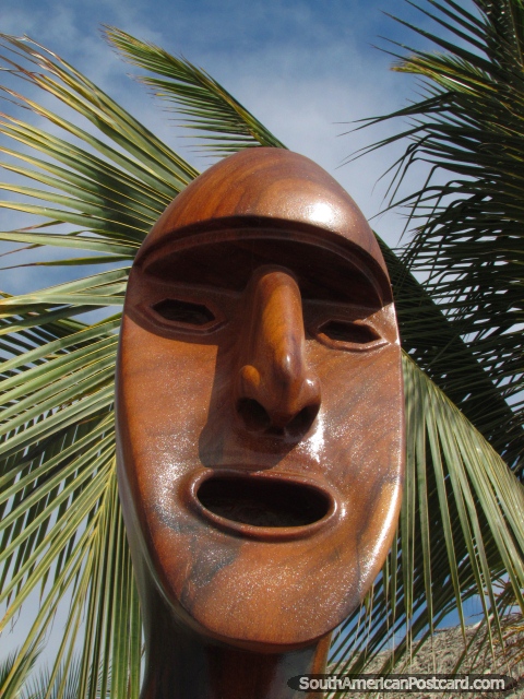 A cara de madeira esculpida e a palma partem em Mancora. (480x640px). Peru, América do Sul.