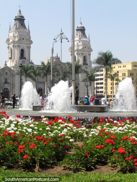 A catedral de Lima atrás de um canteiro de flores vermelhas e brancas e uma fonte. (480x640px). Peru, América do Sul.
