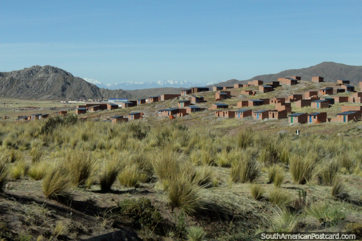 Pequenos edifïcios de tijolos e montanhas nevosas na distância em volta de Desaguadero, a cidade de borda dual do Peru e a Bolïvia. (720x480px). Peru, América do Sul.