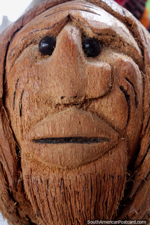 Mans face carved from a large coconut or piece of tree, beady eyes, crafts of Tingo Maria. (480x720px). Peru, South America.