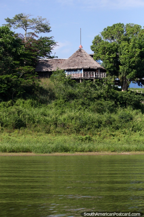 Uma casa de telhado coberta com palha nos bancos do Lago Yarinacocha em Pucallpa. (480x720px). Peru, América do Sul.