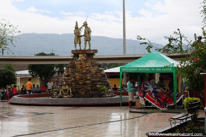 Gold statues (indigenous and Spanish) shake hands upon a stone fountain at the plaza in Lamas, another sits below. (720x480px). Peru, South America.