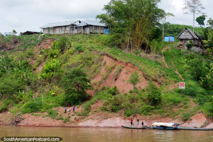 Aldeões abaixo pela água, casas na colina, uma hora abaixo rio de Yurimaguas em 13kmph. (720x480px). Peru, América do Sul.