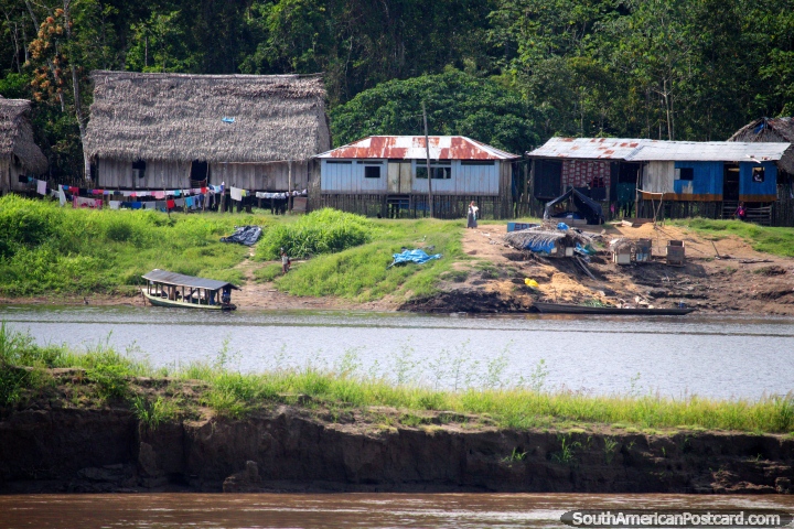 La mujer agita una camisa blanca para decirle al ferry que disminuya la velocidad para que alguien pueda salir en canoa en Ollanta, la Amazonas. (720x480px). Per, Sudamerica.