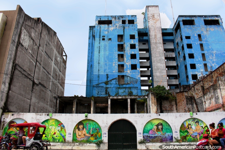 The arched murals and the huge eyesore blue building in Iquitos, view from the plaza. (720x480px). Peru, South America.