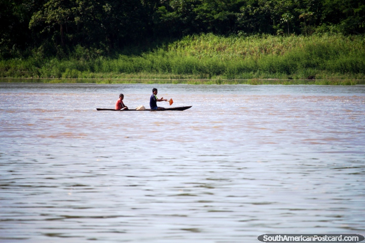 Um par de habitantes locais em uma canoa de rio no Amazônia entre Iquitos e Santa Rosa. (720x480px). Peru, América do Sul.