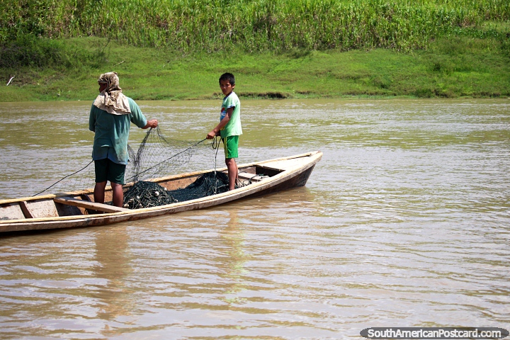 Un hombre y su hijo establecen redes de pesca en el Ro Amazonas en Alfaro, al oeste de Santa Rosa. (720x480px). Per, Sudamerica.