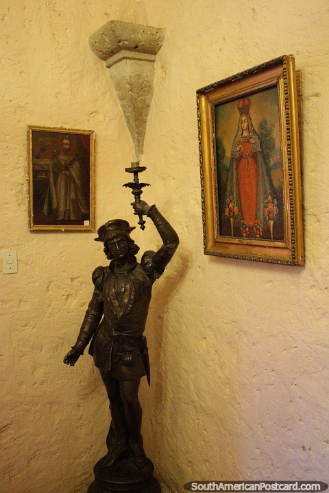 A fancy candle holder, statue figure and paintings at the mansion of the founder of Arequipa. (480x720px). Peru, South America.