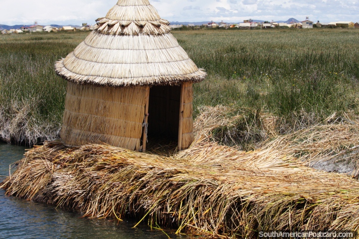 Ao redor de cabana coberta com palha que se senta em canas flutuam junto das águas em Lago Titicaca em Puno. (720x480px). Peru, América do Sul.
