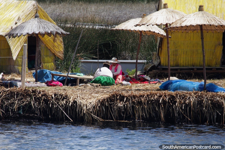 Women make crafts beneath thatched umbrellas on the floating reed islands of
Puno. (720x480px). Peru, South America.
