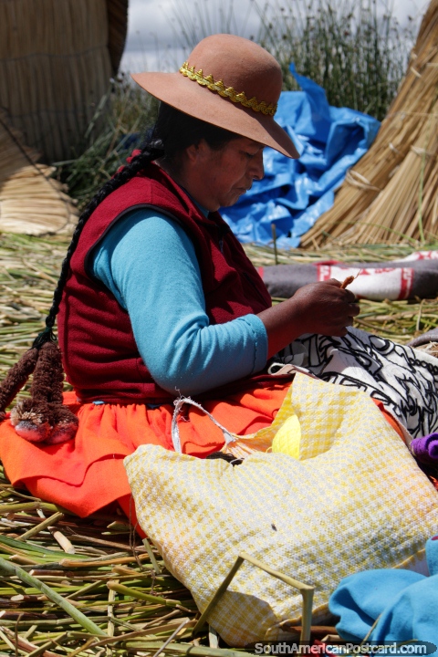 An Uros woman makes crafts, she lives on a floating reed island in Puno. (480x720px). Peru, South America.