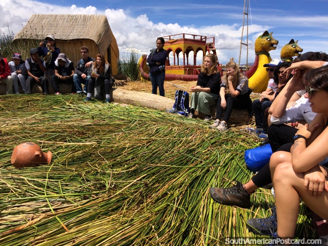 Group tour of a floating reed island, guide is explaining about the history, Puno. (640x480px). Peru, South America.