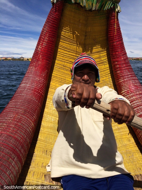 O homem que tem 6 famïlias rema o seu barco de dragão através do Lago Titicaca em Puno. (480x640px). Peru, América do Sul.