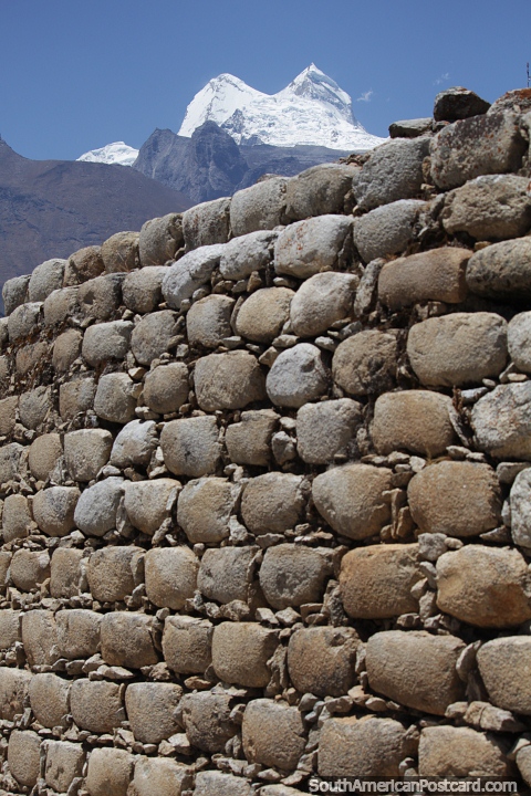 Stone wall at the Tumshukayko ruins and a snowy peak in Caraz. (480x720px). Peru, South America.