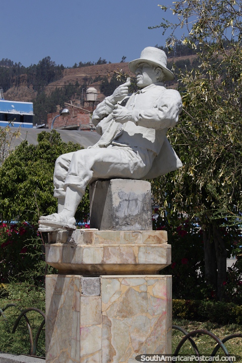 Man sitting eating, white cultural statue at the park in Huaraz. (480x720px). Peru, South America.