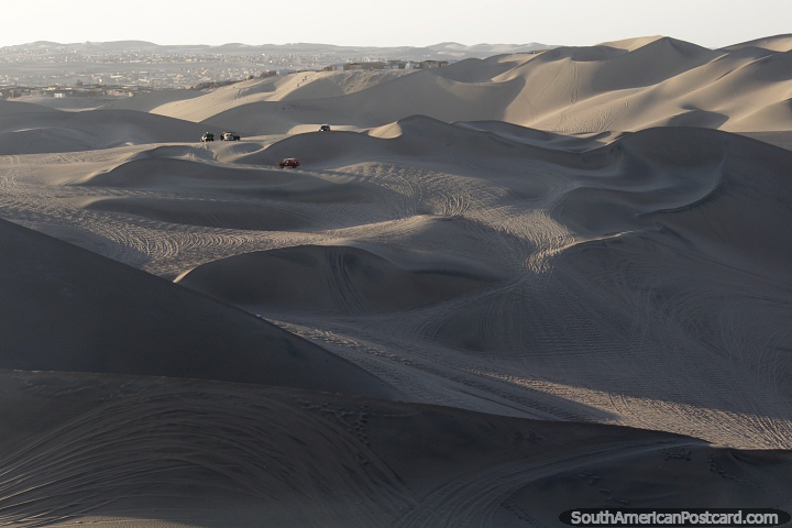 Vast sand dunes dwarf the dune buggies that cruise around them in Huacachina. (720x480px). Peru, South America.