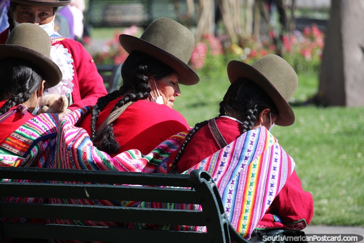 Mujeres indgenas con sombreros marrones y camisetas rojas se sientan en la plaza de Cusco. (720x480px). Per, Sudamerica.