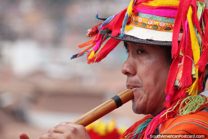 Man blows a wooden flute while wearing a multicolored hat in Cusco. (720x480px). Peru, South America.