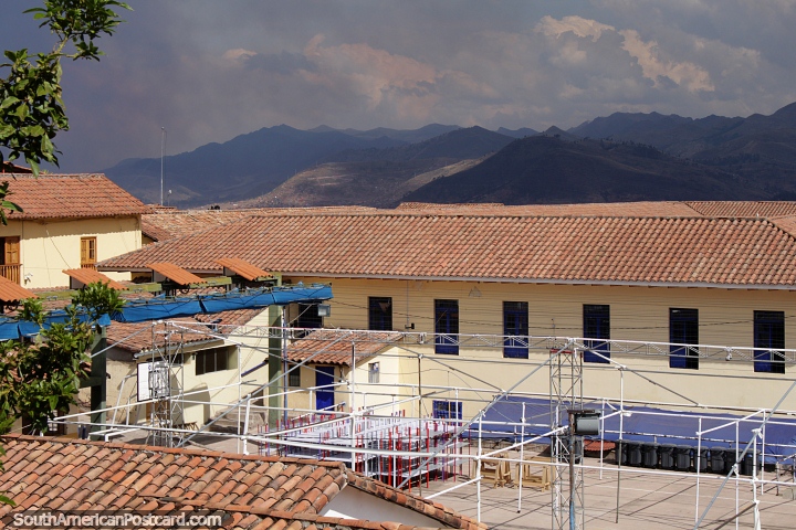 Montanhas ao longe, acima dos edifícios de azulejos vermelhos em Cusco. (720x480px). Peru, América do Sul.