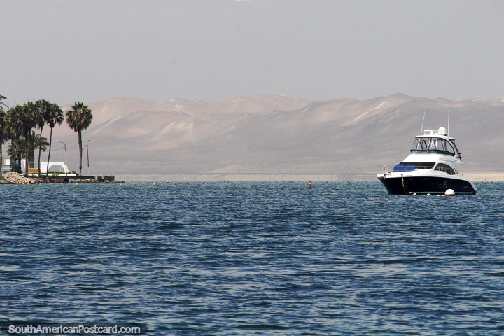 A costa em Paracas com palmeiras e montanhas distantes, barco ancorado. (720x480px). Peru, Amrica do Sul.
