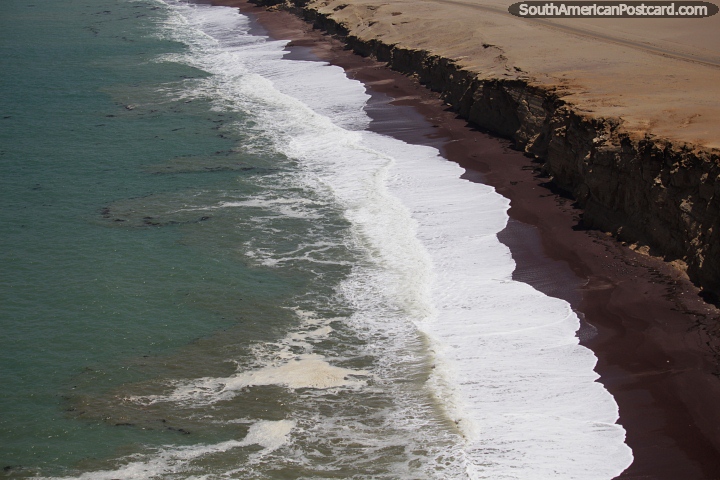 Waves come crashing in and sweep up red stone beach at Paracas National Park. (720x480px). Peru, South America.