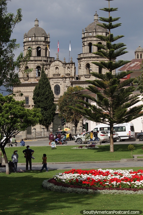 Jardins floridos e gramados verdes na praça com a Igreja de São Francisco em Cajamarca. (480x720px). Peru, América do Sul.