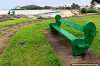 Green bench seats to go with the green surroundings, beach in the distance, Cayenne, French Guiana. The 3 Guianas, South America.