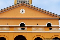 The front facade of the cathedral with clock, mustard color, Cayenne, French Guiana.