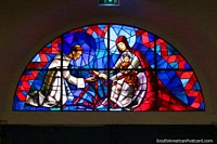 Red and blue stained glass window, man, woman and child, at the cathedral in Cayenne, French Guiana. The 3 Guianas, South America.