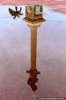 A reflection in a puddle of the tall monument in central Cayenne in French Guiana. The 3 Guianas, South America.