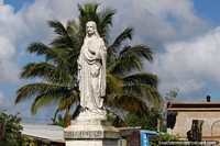 Estatua blanca de Jess en Albina - Surinam, el hombre en el techo cerca. Las 3 Guayanas, Sudamerica.