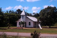 White and green church surrounded by trees between Albina and Paramaribo, Suriname. The 3 Guianas, South America.