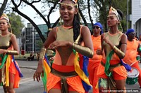 Uma bonita mulher vestiu-se em cores douradas e nacionais na pompa de Avondvierdaagse em Paramaribo, Suriname. As 3 Guianas, América do Sul.