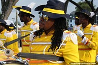 Drummer man with plaited hair and dressed in yellow at the Avondvierdaagse parade in Paramaribo, Suriname. The 3 Guianas, South America.