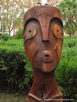 Mask-like wooden sculpture at Plaza San Martin in Colon. Argentina, South America.