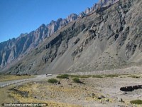 Versión más grande de Torre de montañas enorme encima del camino y todos alrededor en el camino abajo hacia Mendoza.