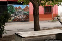 Mural of a farm below mountains on a pink house at the Paseo de las Poetas in Salta. Argentina, South America.