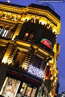 Larger version of The Galerias Pacifico building with golden lights at night in Buenos Aires.