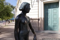 Bronze sculpture of a woman standing on a street corner in Resistencia. Argentina, South America.