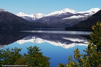 Mirror reflections on a ultra-smooth lake of snowy mountains between Bariloche and El Bolson. Argentina, South America.