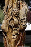 Faces carved into a tree trunk, great craftsmanship at Plaza Pagano in El Bolson. Argentina, South America.