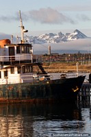 Boat docked at port and distant snowy mountains make a beautiful scene in Ushuaia. Argentina, South America.