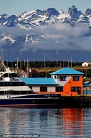 Larger version of The Ushuaia Explorer boat docked at the port and beautiful mountains behind.