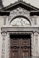 Larger version of Amazing doorway in Santa Fe with engraved sculptures made of stone surrounding it.