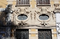 2 caras e 2 janelas ovais nesta fachada de edifïcio interessante em Santa Fé. Argentina, América do Sul.