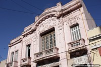 An old pink building facade seen while exploring the historic streets in Santa Fe. Argentina, South America.
