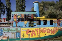 Larger version of Viedma, doorway of the Patagonia, colorfully painted boat beside the river.