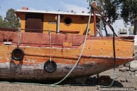 Versão maior do Barco de pesca de madeira na praia, esperando a maré, San Antonio Oeste.