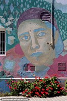 Colorful street art above a colorful garden of flowers in Trelew. Argentina, South America.