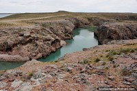Secluded waterway surrounded by a rocky terrain in Puerto Deseado. Argentina, South America.